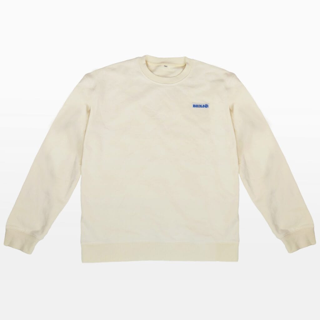 Cream crewneck sweatshirt with ribbed cuffs and hem, laid flat on a white background, featuring a small blue Benjo World logo on the left.